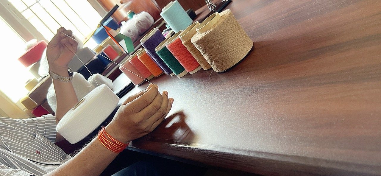 Colored OE yarn cones being checked